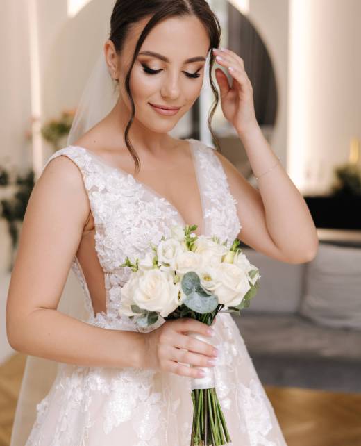 Portrait of beautiful bride hold wedding bouquet. Attractive young woman in gorgeous wedding dress. High quality photo
